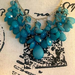 Teal beads with silver chain and adjustable clasp closure.